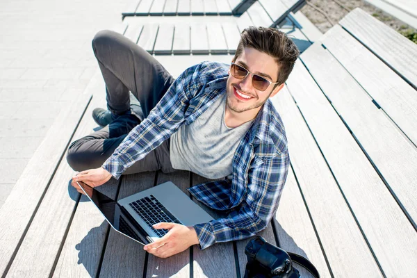 Joven fotógrafo con portátil y cámara fotográfica —  Fotos de Stock