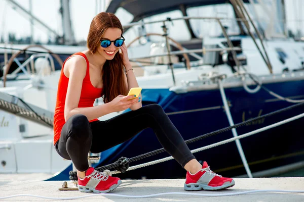 Женщина, сидящая возле яхт — стоковое фото