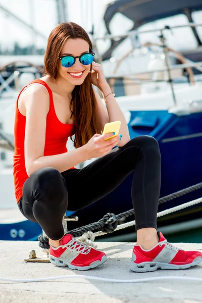 Женщина, сидящая возле яхт — стоковое фото