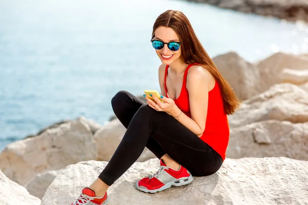 Donna sportiva sulla spiaggia rocciosa — Foto Stock