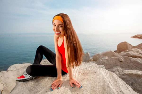 Sport woman on the rocky beach — Stock Photo, Image