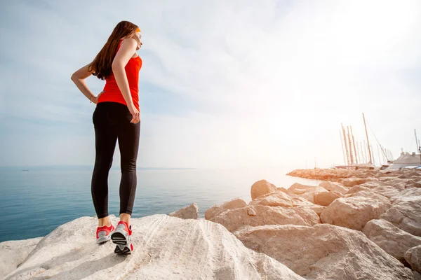 Spor kadın kayalık plaj — Stok fotoğraf