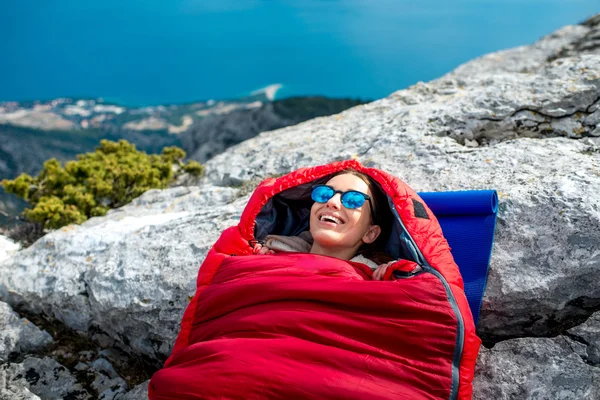 Femme dans un sac de couchage sur la montagne — Photo