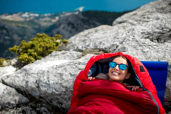 Femme dans un sac de couchage sur la montagne — Photo