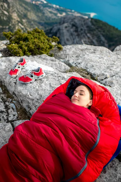 Femme dans un sac de couchage sur la montagne — Photo