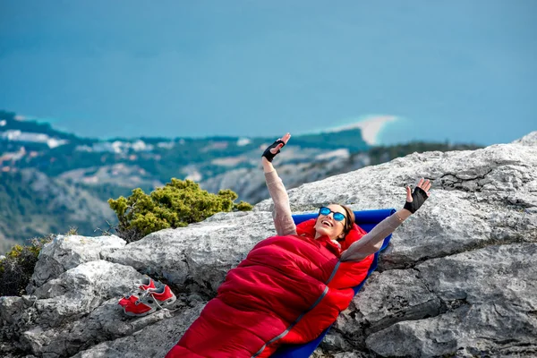 Vrouw in slaapzak op de berg — Stockfoto