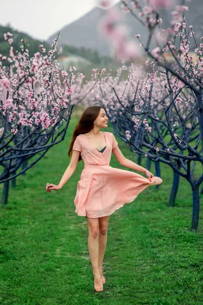 Mujer disfrutando de la primavera en el campo verde con árboles florecientes —  Fotos de Stock