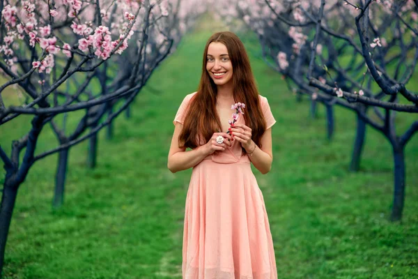 Mujer disfrutando de la primavera en el campo verde con árboles florecientes —  Fotos de Stock