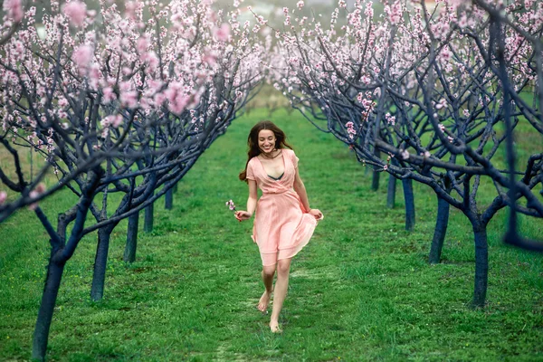 Mujer disfrutando de la primavera en el campo verde con árboles florecientes —  Fotos de Stock