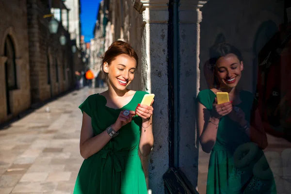 Mujer con teléfono móvil en la calle de la ciudad vieja — Foto de Stock