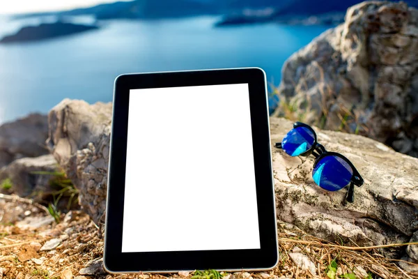 Tableta digital con gafas de sol en la montaña —  Fotos de Stock