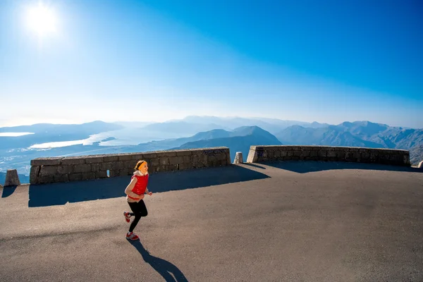 Donna che corre sulla strada di montagna — Foto Stock