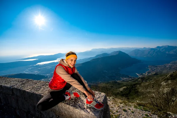 Vrouw onder oefening over de bergweg — Stockfoto