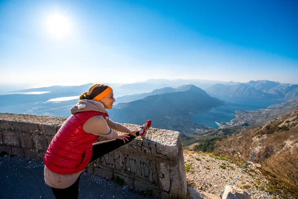 Donna che fa esercizio sulla strada di montagna — Foto Stock