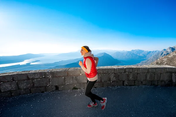 Donna che corre sulla strada di montagna — Foto Stock