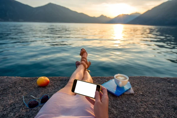 Mujer sosteniendo el teléfono acostado en el muelle — Foto de Stock