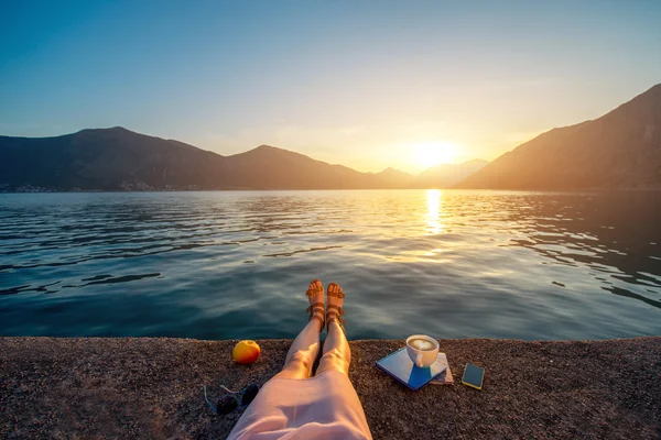 Womans legs on the pier at sunset — Stock Photo, Image
