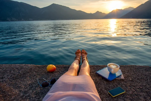Womans legs on the pier at sunset — Stock Photo, Image