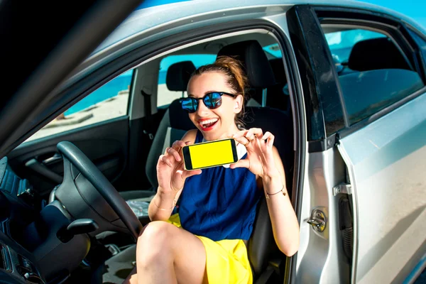 Frau zeigt Handybildschirm im Auto — Stockfoto