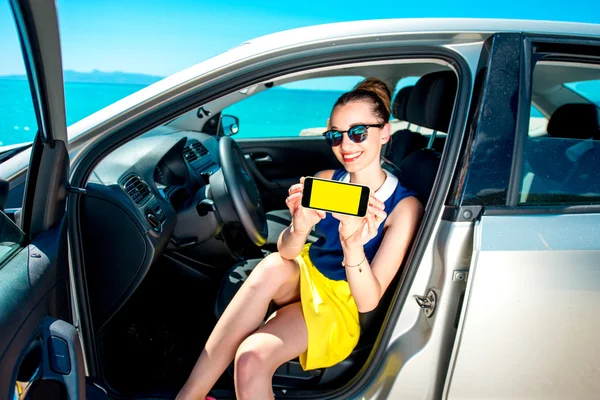 Женщина показывает экран телефона в машине — стоковое фото