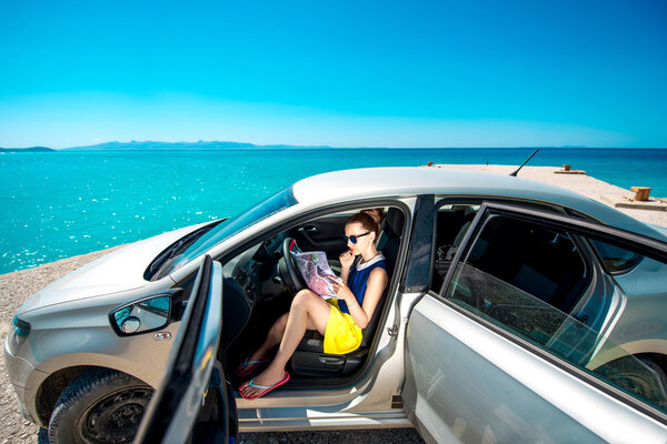 Young traveler with map sitting in the car