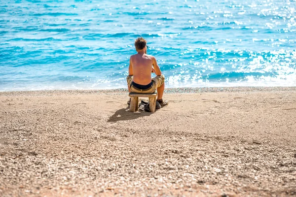 Homem lendo livro na praia — Fotografia de Stock