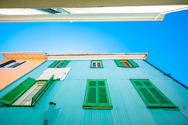 Colorful facade with green shutters on windows