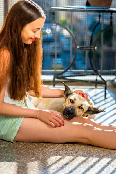 발코니에 그녀의 강아지와 함께 젊은 여성 — 스톡 사진