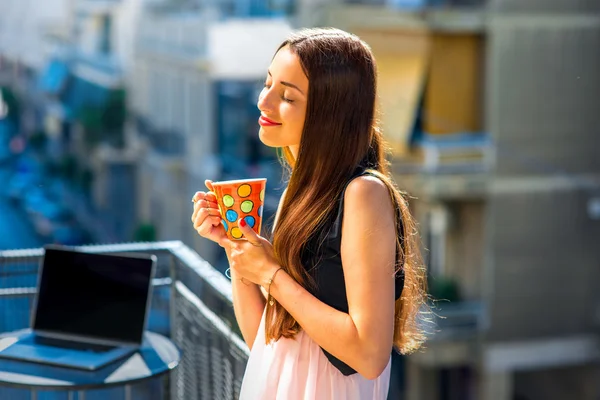 Mujer con taza de café de colores en el balcón — Foto de Stock