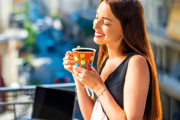 Donna con tazza di caffè colorato sul balcone — Foto Stock