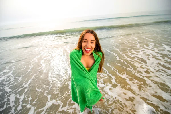 Frau in grünem Handtuch am Strand — Stockfoto