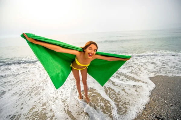 Mujer en toalla verde en la playa — Foto de Stock