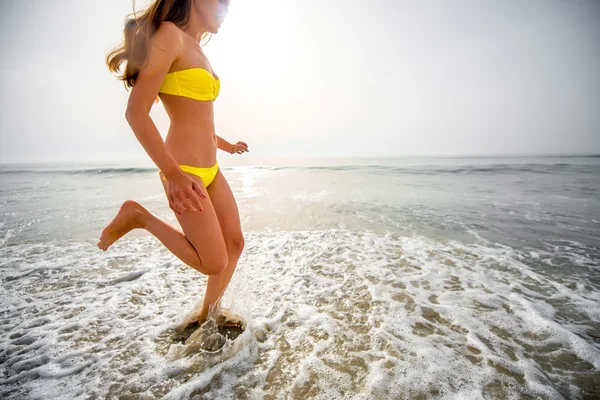 Frau läuft am Strand — Stockfoto