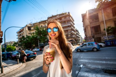 Woman walking on the street with take away coffee  clipart