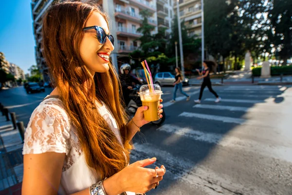 Женщина ходит по улице с кофе на вынос — стоковое фото