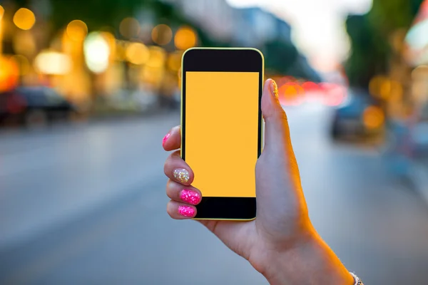 Holding phone on street background — Stock Photo, Image