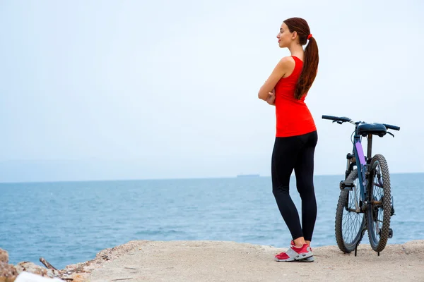 Mulher do esporte com bicicleta na praia — Fotografia de Stock