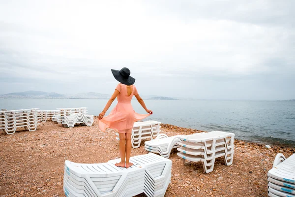 Vrouw op het verlaten strand met vele zonnebedden — Stockfoto