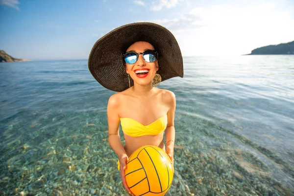 Mulher com bola amarela no mar — Fotografia de Stock