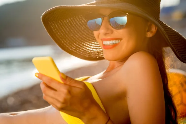 Mulher usando telefone celular na praia — Fotografia de Stock