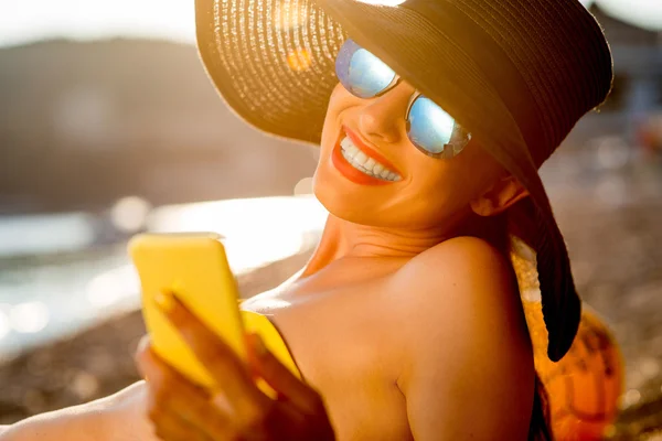 Mulher usando telefone celular na praia — Fotografia de Stock