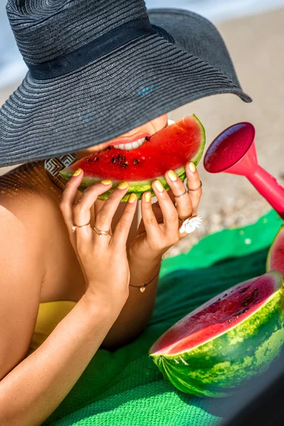 Kobieta jedząca arbuza na plaży — Zdjęcie stockowe