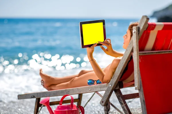 Woman using tablet on the sunbed — Stockfoto