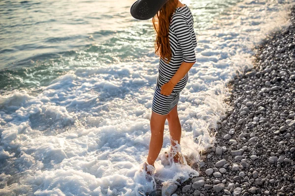 Mujer en vestido desnudo con un sombrero en la playa — Foto de Stock