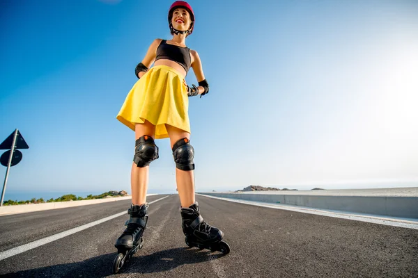 Sport woman with rollers on the highway — 图库照片