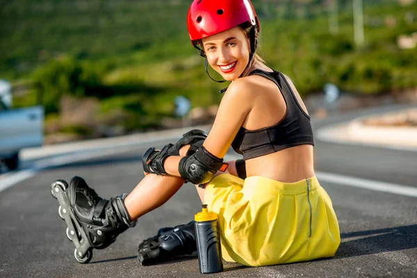 Sport woman with rollers on the highway — Stockfoto