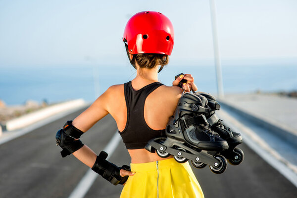 Sport woman with rollers on the highway
