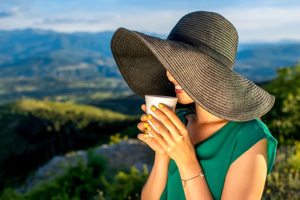 Женщина с чашкой кофе в горах — стоковое фото
