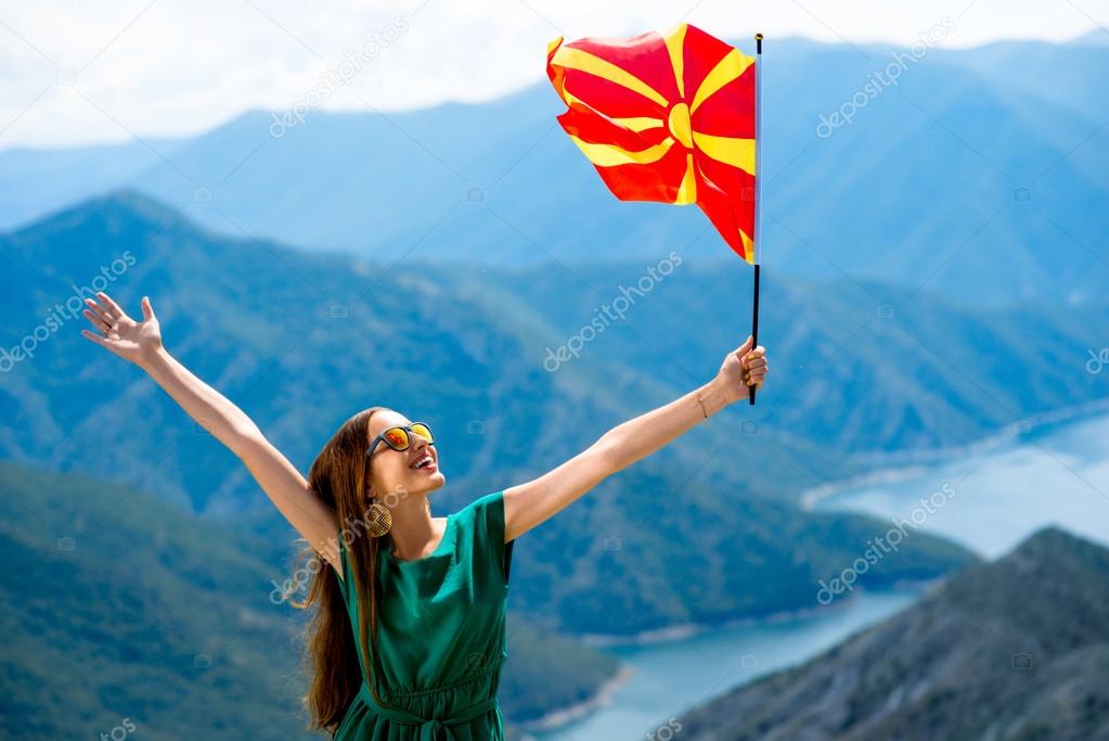 Woman with macedonian flag on the top of mountain