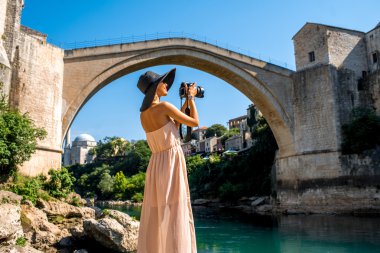 Woman photographing city view in Mostar clipart